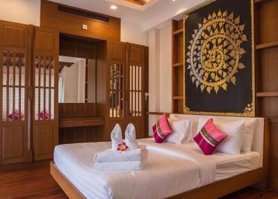 Spacious bedroom with wooden decor and artistic wall hanging