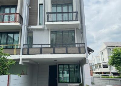 Front view of a three-story townhouse with balconies.