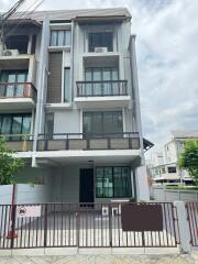 Front view of a three-story townhouse with balconies.