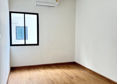 Empty bedroom with wooden floor and air conditioner