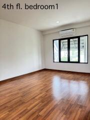 Empty bedroom with wooden floor and large window