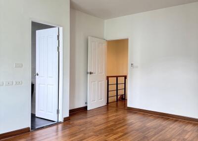4th floor bedroom with wooden flooring and open doors