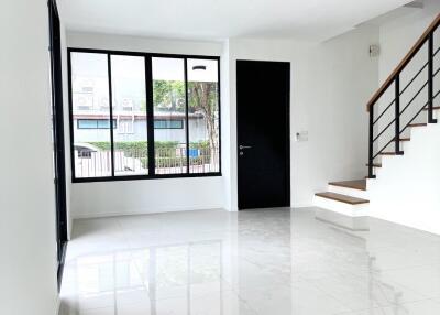 Spacious living area with large windows and tiled floor