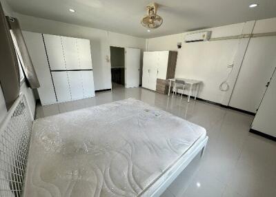 Spacious bedroom with white furniture and a bed