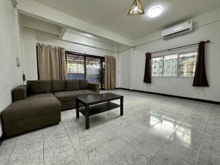 Spacious living room with sofa, coffee table, and large windows