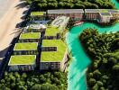 Aerial view of modern beachfront apartment complex with green roofs and a river running through the property