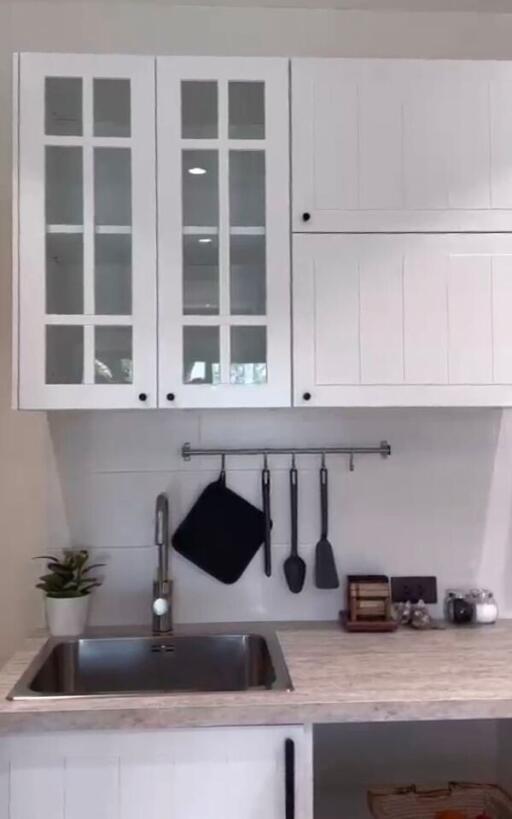 Modern kitchen with white cabinets and stainless steel sink