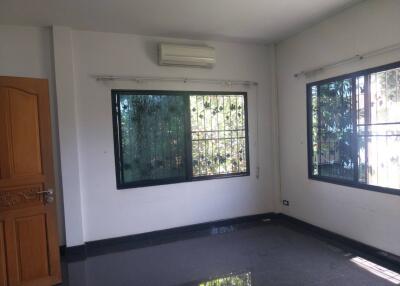 Empty living room with windows and an air conditioner