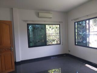 Empty living room with windows and an air conditioner