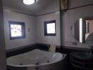 Modern bathroom with jacuzzi tub and round mirror