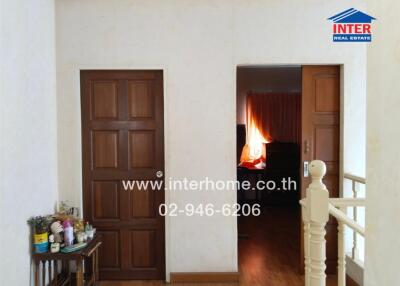 Hallway with wooden doors and a staircase