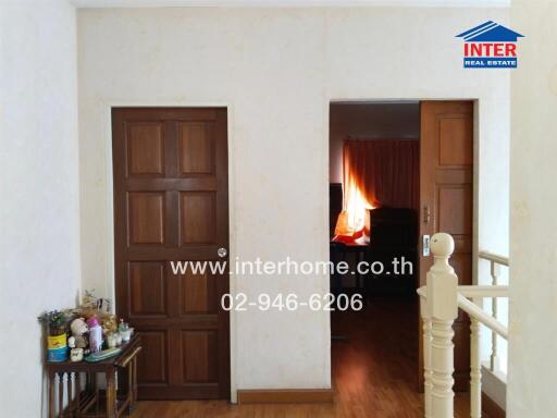 Hallway with wooden doors and a staircase