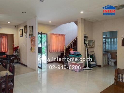 Main living space with dining area, staircase, and bathroom entrance