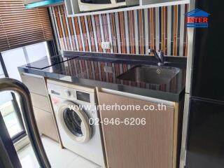 Modern kitchen with washing machine and colorful backsplash