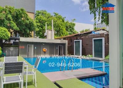 Outdoor pool area with seating and greenery