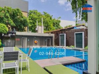 Outdoor pool area with seating and greenery