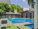 Outdoor pool area with seating and greenery