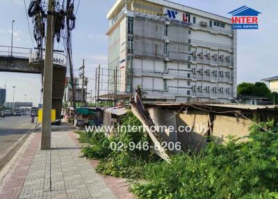 Building with adjacent overgrown sidewalk and street