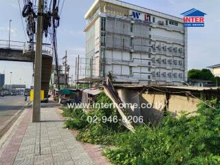 Building with adjacent overgrown sidewalk and street