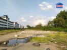 Vacant land with some vegetation and nearby buildings