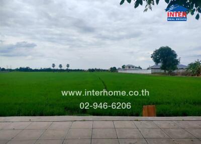 View of green fields with contact information for real estate