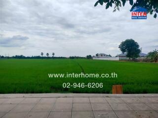 View of green fields with contact information for real estate