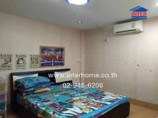 Bedroom with colorful bedspread and air conditioning