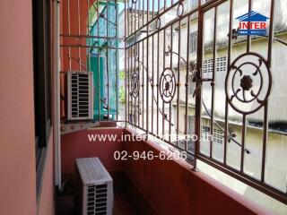 Small balcony with metal railing and air conditioning units