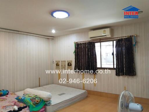 Simple bedroom setup with a mattress on the floor, window with curtains, air conditioner, and playful children