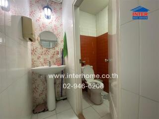 Bathroom with a pedestal sink, mirror, and toilet