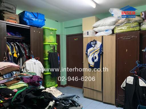 Cluttered bedroom with wardrobes and clothing