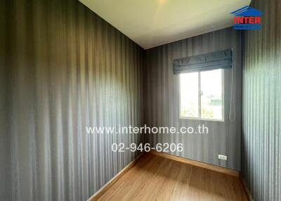 Empty bedroom with wooden floor and striped wallpaper