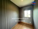 Empty bedroom with wooden floor and striped wallpaper