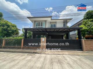 Two-story residential building with a gated yard