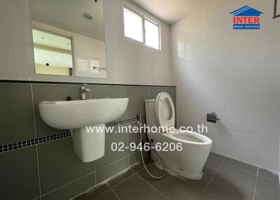 Modern bathroom with sink, toilet, and mirror