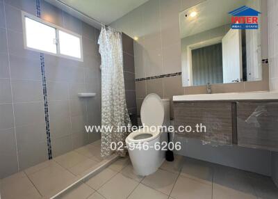 Modern bathroom with shower, toilet, vanity, and large mirror