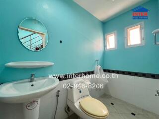 Bathroom with blue walls, sink, toilet, and urinal