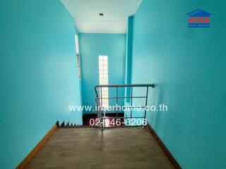 Bright and airy hallway with wooden floors and sky-blue walls