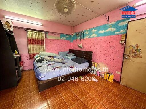 Bedroom with pink walls, bed, and personal belongings