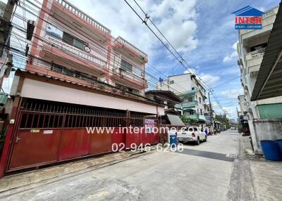 Street view of residential buildings with contact details visible