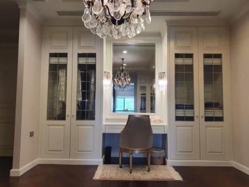 Elegant bedroom with a chandelier, mirror, and built-in wardrobes