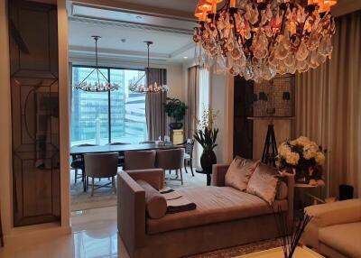 Elegant living and dining area with chandeliers and city view