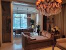 Elegant living and dining area with chandeliers and city view