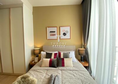 Modern bedroom with bed, nightstands, lamps, and large window
