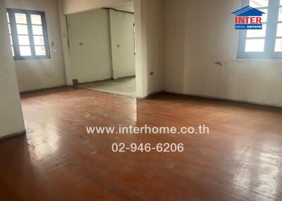 Unfurnished main living area with wooden flooring and windows