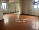 Unfurnished main living area with wooden flooring and windows