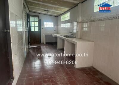 Kitchen with tiled walls, countertops, and sink