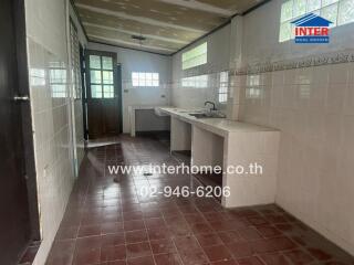 Kitchen with tiled walls, countertops, and sink