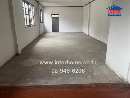 Spacious empty room with concrete floor and large windows