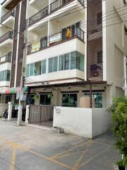 Exterior view of a multi-story residential building with balconies and entrance